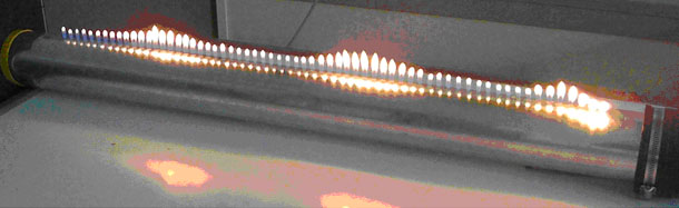 Motiv Physik Foto eines Versuchsaufbaus mit Kerzen, die unterschiedlich große Flammen haben. Das